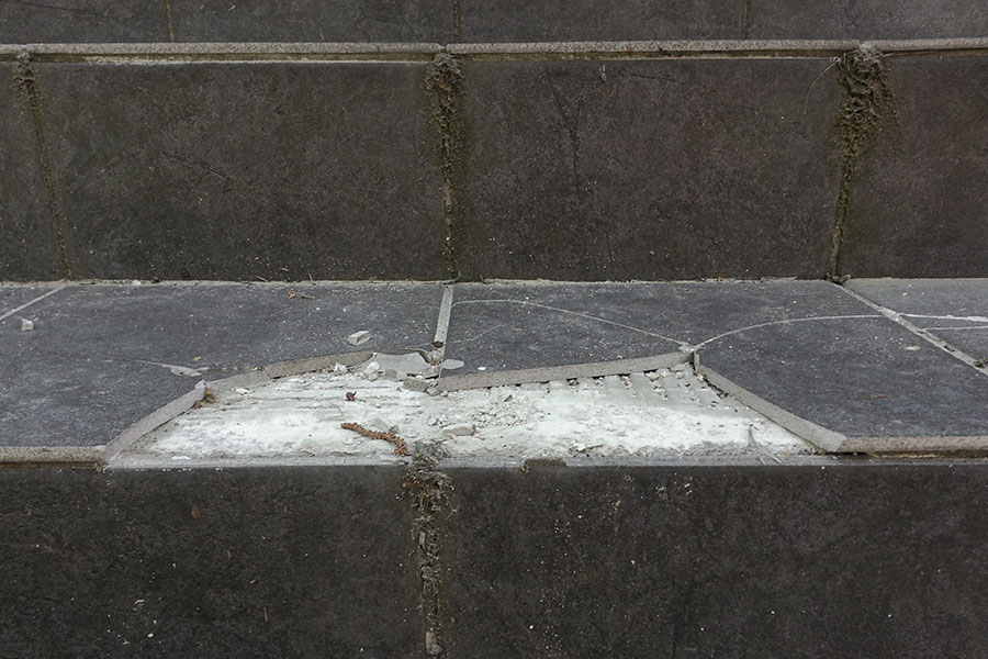 Klinker på betongtrappa som lossnat och spruckit sönder